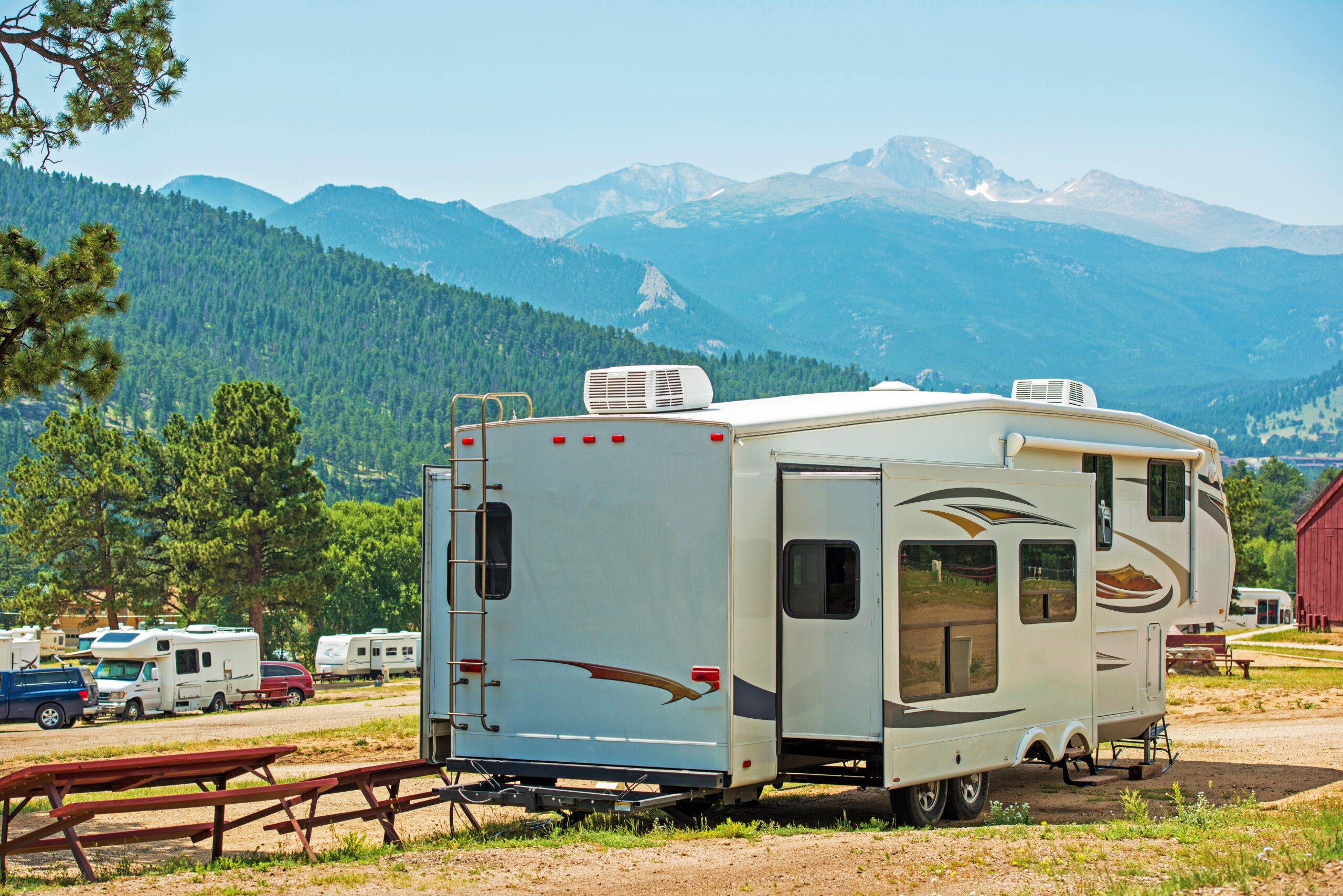 RV Fifth Wheel Camping. Travel Trailer with Extended Sliders in the Mountain Campground.